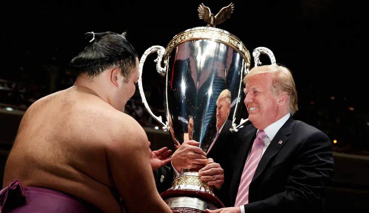Presiden AS Donald Trump (kanan) memberikan trofi President's Cup kepada pemenang Tokyo Grand Sumo Tournament di Stadion Ryogoku Kokugikan, Tokyo, Jepang, Minggu (26/5/2019). Nonton bareng ini dilakukan di sela-sela kunjungan kenegaraan Trump ke Jepang. (AP Photo/Evan Vucci)