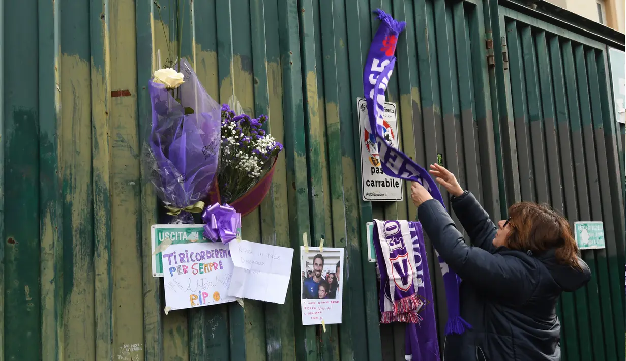 Penggemar menggantung syal ungu Fiorentina di pagar luar Stadion Artemio Franchi di Florence, Minggu (4/3). Fans melakukan aksi belasungkawa untuk mengenang sosok kapten Fiorentina Davide Astori yang meninggal dalam tidurnya. (Claudio GIOVANNINI/AFP)