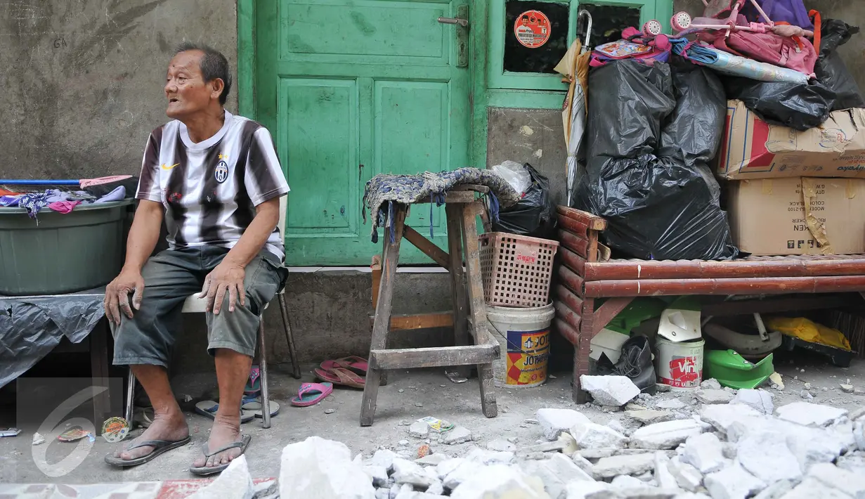 Warga menunggu bangunan miliknya selesai dibongkar petugas Satpol PP di kawasan Petojo Utara VI Kecamatan Gambir, Jakarta, Rabu (30/9/15). Lokasi tersebut nantinya akan difungsikan untuk normalisasi kali Krukut. (Liputan6.com/Gempur M Surya) 