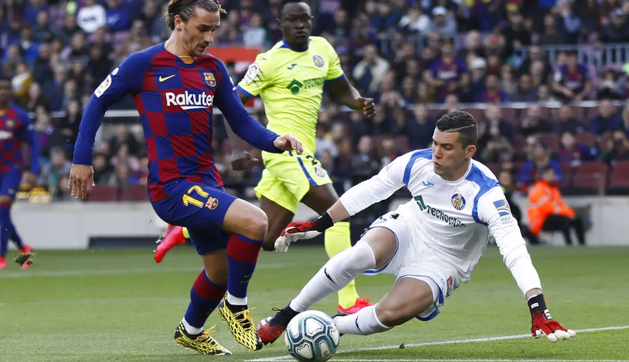 Penyerang Barcelona, Antoine Griezmann, berusaha melewati kiper Getafe, David Soria, pada laga La Liga di Stadion Camp Nou, Sabtu (15/2/2020). Barcelona menang 2-1 atas Getafe. (AP/G.Garin)