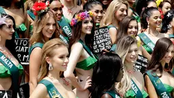 Kontestan Miss Earth 2019 berpose dalam balutan baju renang dengan pesan mereka untuk menyelamatkan Mother Earth saat sesi media di Manila, Rabu (2/10/2019). Malam final kontes Miss Earth 2019 ini akan digelar pada 26 Oktober mendatang di Filipina. (AP/Bullit Marquez)