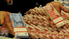 Petugas memperlihatkan uang palsu pecahan Rp 50 ribu dan Rp 100 ribu saat rilis kasus di Bareskrim Mabes Polri, Jakarta, Jumat (22/7). Bareskrim mengungkap sindikat uang palsu di Magelang dengan barang bukti uang palsu Rp 7 M. (Liputan6.com/Johan Tallo)
