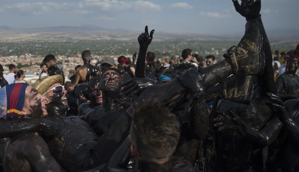 Para peserta dengan tubuh dilumuri minyak hitam mengikuti Festival Tradisionlal Cascamorras di Baza, Granada, Spanyol (6/9/2019). Festival ini diadakan setiap tanggal 6 September dan telah berlangsung selama 500 tahun terakhir. (AFP Photo/Jorge Guerrero)