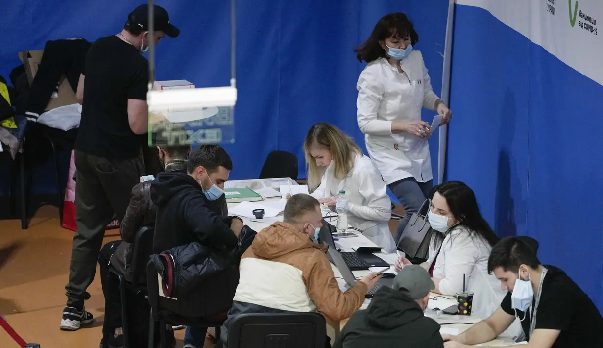 Orang-orang menunggu giliran di pusat vaksinasi di mal kota di Kyiv, Ukraina, Senin (1/11/2021). Otoritas Kyiv memerintahkan orang memiliki sertifikat vaksinasi atau tes Corona untuk memasuki transportasi umum, pusat perbelanjaan, pusat olahraga dll. (AP Photo/Efrem Lukatsky)