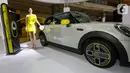 Model berpose di samping mobil MINI Electric pada peluncuran MINI Electric di PIK Avenue Jakarta (08/06/2022). MINI Indonesia hadirkan kendaraan full listrik premium dalam dua varian yaitu MINI Electric dan MINI Electric Collection dengan motor listrik 135 kW/184 hp dan tenaga maksimum 270 Nm. (Liputan6.com/Fery Pradolo)