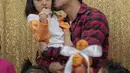 Aktor Denny Sumargo mencium seorang anak saat merayakan ulang tahunnya yang ke-37 di Panti Asuhan Dorkas, Jakarta, Kamis (11/10). (Liputan6.com/Faizal Fanani)