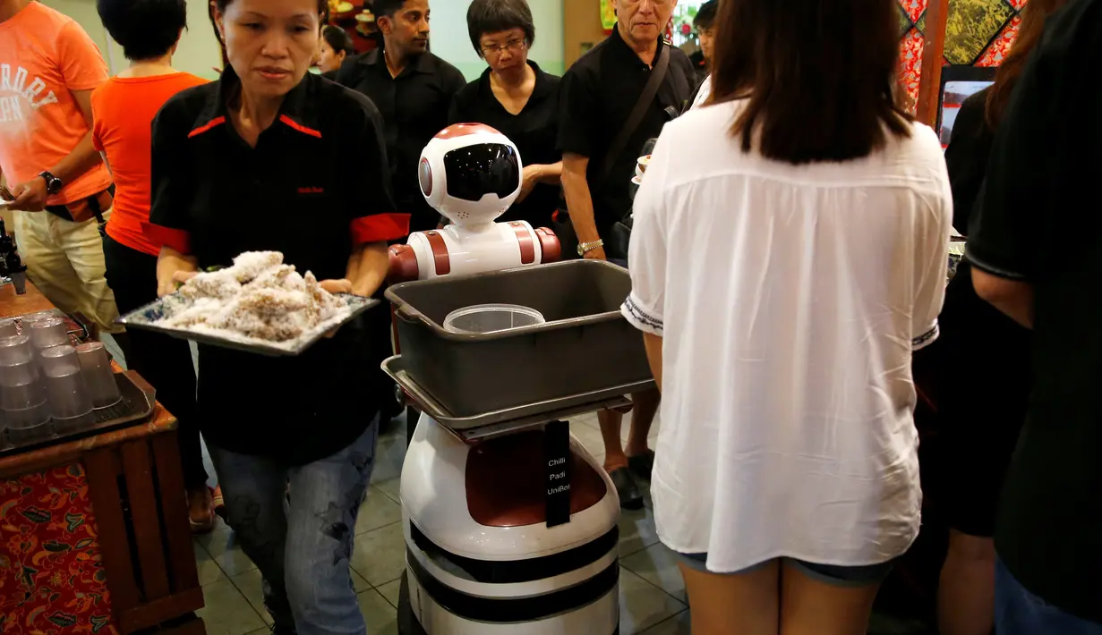 Robot mengumpulkan piring-piring tamu yang telah kotor di Chilli Padi Nonya Cafe, Singapura, (6/7).Pengembangan robot di Singapura masih dalam uji coba tetapi sudah banyak perusahaan yang ingin memperkejakan robot. (REUTERS / Edgar Su)