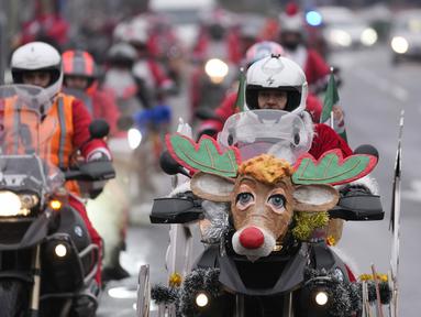 Pengendara sepeda motor yang mengenakan kostum Sinterklas mengendarai motor mereka selama parade Sinterklas di Beograd, Serbia, Minggu (26/12/2021). Mereka melakukan konvoi menuju rumah sakit anak-anak untuk membagikan mainan hadiah Natal kepada pasien di sana. (AP Photo/Darko Vojinovic)