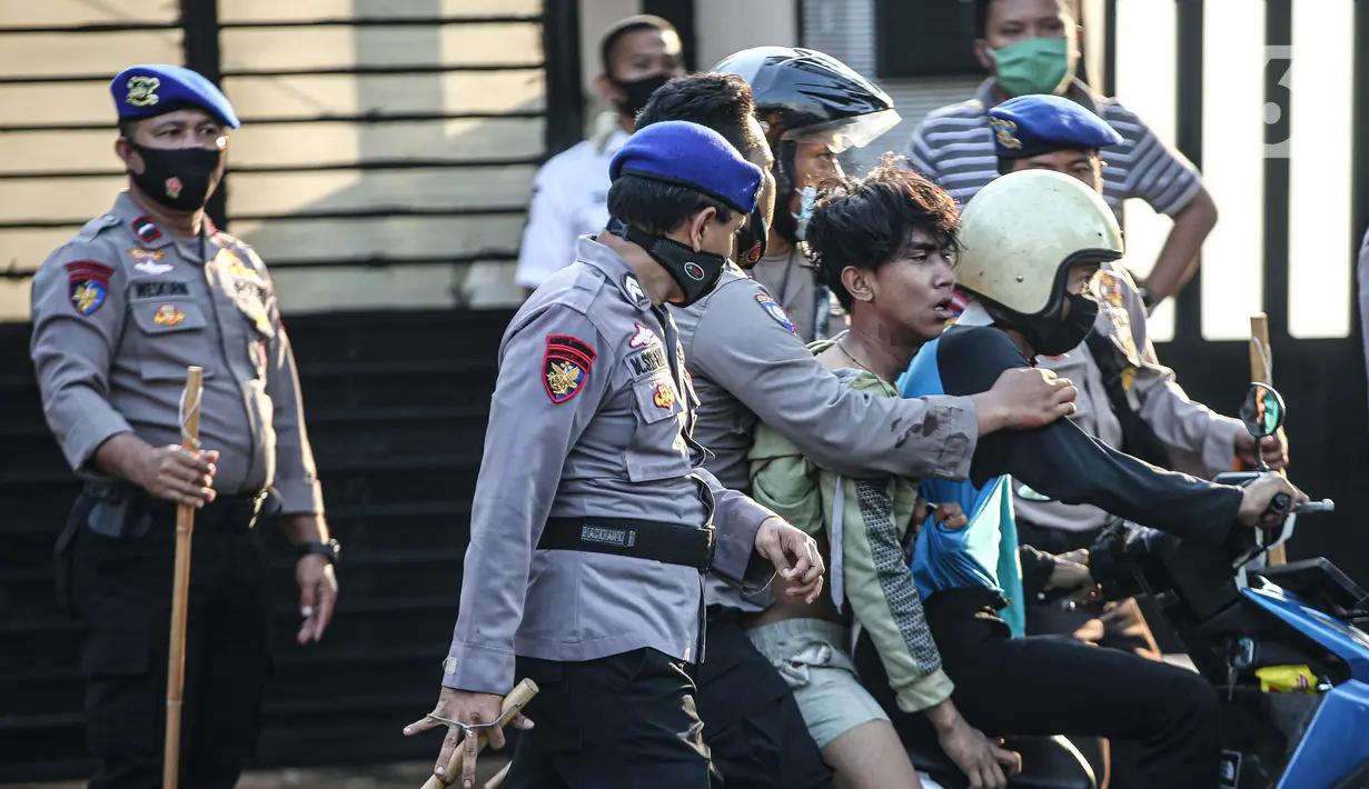 Polisi membawa seorang pria saat terjadi bentrok di kawasan Pejompongan, Jakarta, Rabu (7/10/2020). Belum bisa dipastikan apakah aksi tersebut berkaitan dengan isu aksi penolakan pengesahan UU Omnibus Law Cipta Kerja. (Liputan6.com/Faizal Fanani)