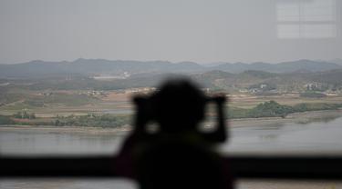 Seorang pengunjung menggunakan teropong untuk melihat sisi Korea Utara dari observatorium unifikasi di Paju, Korea Selatan, Kamis (12/5/2022). Korea Utara memberlakukan lockdown nasional usai mengkonfirmasi kasus COVID-19 untuk pertama kalinya. Kasus subvarian Omicron BA.2 itu terdeteksi di Pyongyang. (AP Photo/Lee Jin-man)