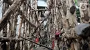 Kondisi tanggul kayu yang rusak dan penuh sampah di bantaran Kali Ciliwung, Rawajati, Pancoran, Jakarta, Minggu (5/1/2020). Tanggul dari kayu dolken dan karung pasir yang baru dibangun pada akhir Desember 2019 itu rusak hingga dipenuhi sampah akibat terjangan arus banjir. (merdeka.com/Iqbal Nugroho)