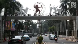 Pekerja beraktivitas membersihkan gerbang masuk jalan Pintu Satu Senayan, Jakarta, Jumat (20/7). Jelang perhelatan Asian Games 2018, sejumlah fasilitas penunjang di kawasan Gelora Bung Karno terus dipercantik. (Liputan6.com/Helmi Fithriansyah)