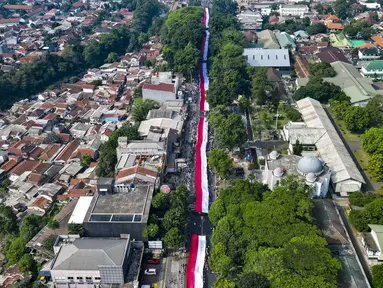 Foto udara ini memperlihatkan sekitar 3.500 orang yang berpartisipasi dalam pawai membawa bendera Indonesia sepanjang 500 meter di Jalan Sudirman Bogor, Jawa Barat, Minggu,  9 Agustus 2026. (AFP/ Aditya Aji)