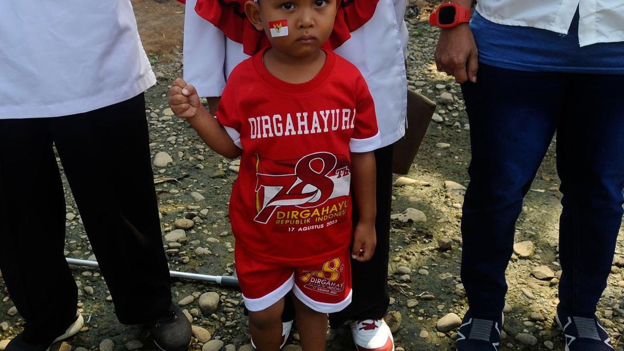 Tak hanya orang dewasa, sejumlah anak juga ikut meramaikan momen pengibaran bendera merah putih pada aliran Sungai Ciliwung yang hampir mengering di Kedung Halang Kota Bogor, Kamis (17/08/2023).