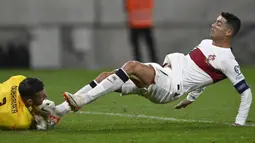 Pemain Portugal, Cristiano Ronaldo (kanan) berusaha merebut bola dari kiper Slovakia, Martin Dubravka saat laga grup G Kualifikasi Euro 2024 di National Football Stadium in Bratislava, Slovakia, Sabtu (9/9/2023) dini hari WIB. (AP Photo/Radovan Stoklasa)