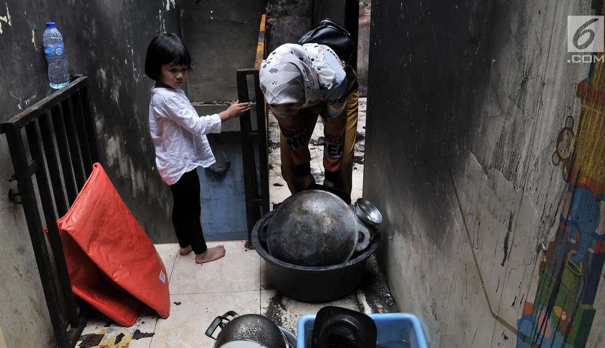 Warga mengumpulkan sisa barang setelah kebakaran melanda kawasan Tambora, Jakarta, Kamis (10/1). Para korban masih bertahan di rumahnya meski dengan kondisi memprihatinkan. (Merdeka.com/Iqbal Nugroho)