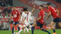 Olivier Giroud coba menganggu Lee Kang-in di laga&nbsp;Lille vs PSG di Stade Pierre-Mauroy di pekan ke tujuh Ligue 1 2025/2026, Senin (06/10/2025). (AP Photo/Jean-Francois Badias)