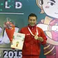 Atlet Wushu Indonesia, Yusuf Widiyanto menerima medali emas pada Kejuaraan Dunia Wushu 2015 di Istora, Senayan, Jakarta, Selasa (17//11/2015). (Bola.com/Nicklas Hanoatubun)