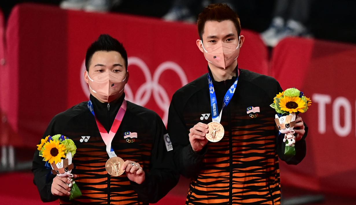 Sementara pada Olimpiade Tokyo 2020, Aaron Chia/Soh Wooi Yik merebut medali perunggu setelah mengalahkan pasangan Indonesia, Mohammad Ahsan/Hendra Setiawan dengan rubber-game, 17-21, 21-17 dan 21-14. (AFP/Pedro Pardo)