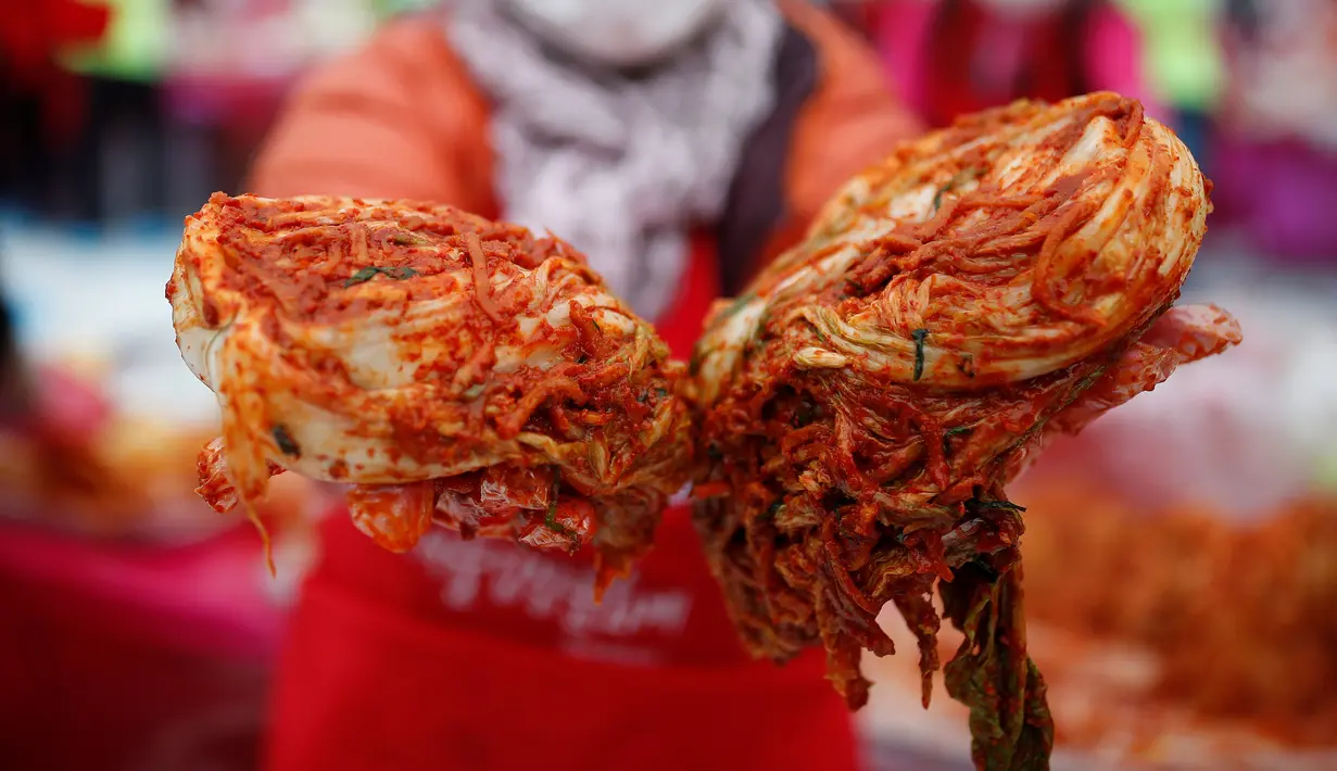 Seorang wanita memperlihatkan Kimchi, hidangan tradisional Korea Selatan, selama Festival Kimchi Seoul di pusat kota Seoul, Jumat (44/11). Kimchi merupakan makanan yang terbuat dari sawi putih atau lobak yang difermentasikan. (REUT (REUTERS / Kim Hong-Ji)