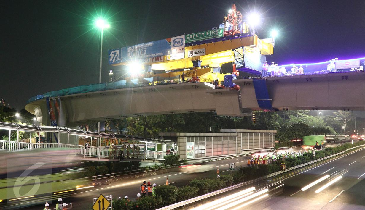 Aktivitas pekerja saat pemasangan box girder ramp 1 Simpang Susun Semanggi di Kawasan Semanggi, Jakarta Selatan, Jumat (10/3). Dengan terpasangnya box girder ke-22 itu, overpass Gatsu (Grogol-Senayan) kini sudah tersambung. (Liputan6.com/Herman Zakharia)