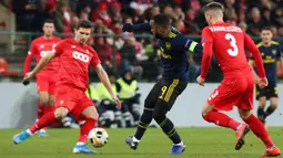 Pemain Arsenal Alexandre Lacazette (tengah) berusaha melewati pemain Standard Liege pada pertandingan Grup F Liga Europa di Stadion Maurice Dufrasne, Liege, Belgia, Kamis (12/12/2019). Arsenal juara grup setelah menahan Standar Liege 2-2. (AP Photo/Francois Walschaerts)