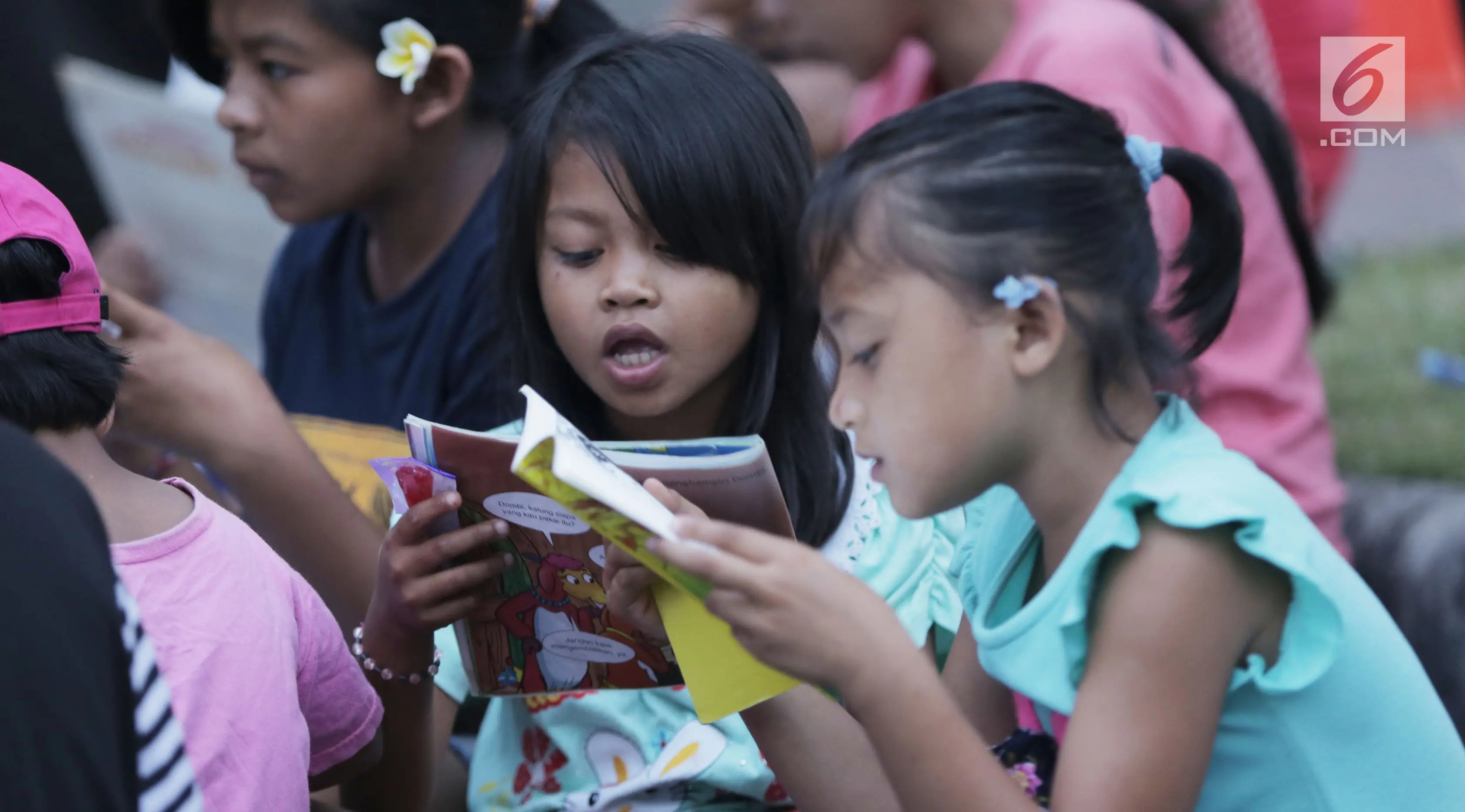 Sejumlah anak membaca buku di mobil Perpustakaan Keliling Dinas Perpustakaan dan Arsip Daerah Kabupaten Klungkung di lokasi pengungsian korban evakuasi Gunung Agung, Klungkung, Bali, Sabtu (30/09). (/Gempur M Surya)