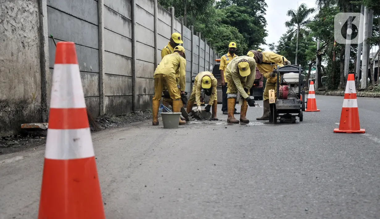Pekerja Suku Dinas Bina Marga Jakarta Utara menyelesaikan perbaikan jalan jelang gelaran balap liar legal di Jalan Inspeksi Kali Ancol, Pademangan, Rabu (12/1/2022). Polda Metro Jaya resmi menjadikan Jalan Inspeksi Kali Ancol sebagai arena balap liar legal. (merdeka.com/Iqbal S. Nugroho)