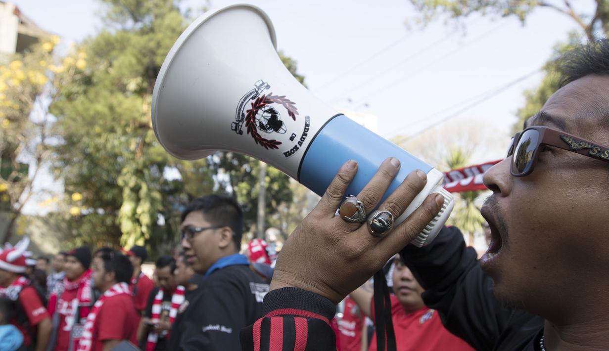 Pendukung Bali United meneriakan yel-yel di depan hotel tempat pemain jelang laga perempat final antara Bali United melawan Arema Cronus di Malang, Sabtu (19/9/2015). (Bola.com/Vitalis Yogi Trisna)