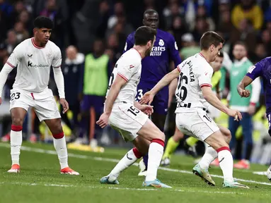 Pemain Real Madrid, Rodrygo, berusaha melewati pemain Athletic Bilbao pada laga Liga Spanyol di Stadion Santiago Bernabeu, Minggu (31/3/2024). (AP Photo/M. Gracia Jimenez)