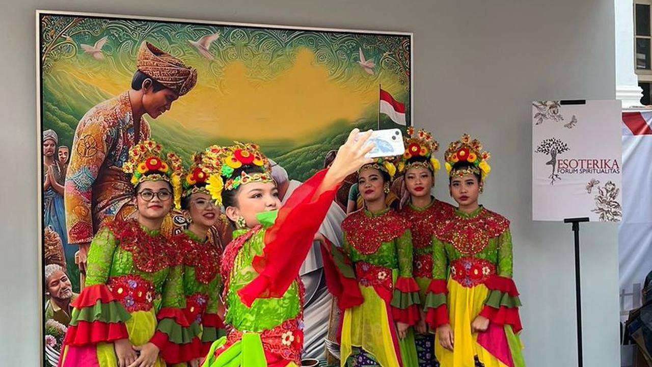 Pengunjung berswafoto di depan lukisan karya Denny JA yang berjudul 'Paus Mencuci Kaki Rakyat Indonesia' dalam Festival Toleransi di Galeri Nasional, Jakarta, Senin (2/9/2024).