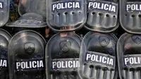 Polisi berlindung menggunakan perisai saat para demonstran melempari mereka dengan batu saat protes terhadap kematian gadis berusia 11 tahun Morena Dominguez di luar kantor polisi di pinggiran Buenos Aires, Argentina, Rabu (9/8/2023). (AP Photo/Natacha Pisarenko)