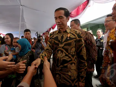 Presiden Jokowi saat pembagian Kartu Indonesia Sehat (KIS), Kartu Indonesia Pintar dan Kartu Keluarga Sejahtera (KKS) kepada masyarakat di Penjaringan, Jakarta, Rabu (13/5/2015). (Liputan6.com/Faizal Fanani)