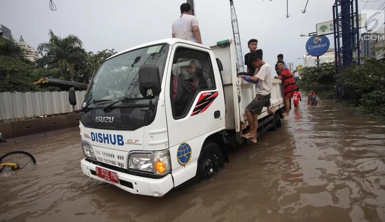Petugas Dinas Perhubungan (Dishub) mengevakuasi karyawan dan warga yang terjebak banjir di Jalan Boulevard Raya, Kelapa Gading, Jakarta, Kamis (15/2). Banjir diakibatkan guyuran hujan sejak pagi hingga sore. (Liputan6.com/Arya Manggala)
