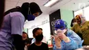 Petugas medis dengan mengenakan topeng superhero bersiap menyuntikkan vaksin Sinonvac kepada anak-anak saat mengikuti vaksinasi kedua di Gedung  Otoritas Jasa Keuangan (OJK), Jakarta, Minggu (16/01/2022). (Liputan6.com/Angga Yuniar)