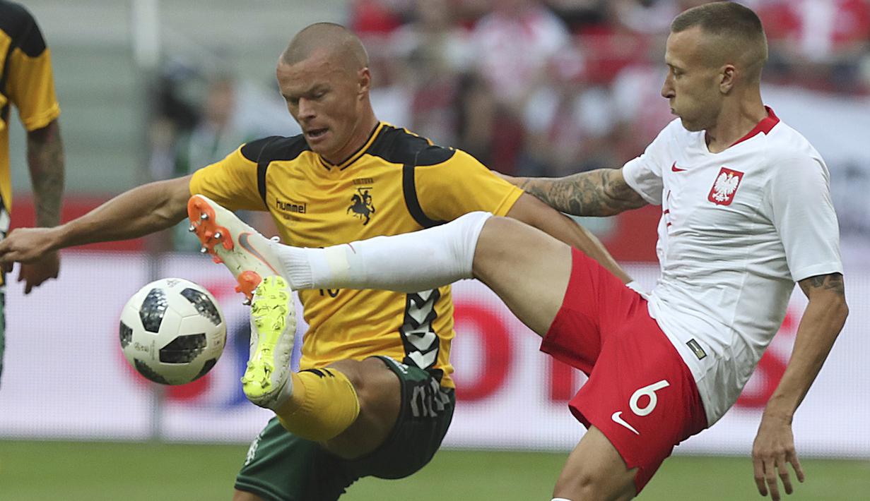 Pemain Polandia,  Jacek Goralski (kanan) berebut bola dengan pemain Lituania, Darvydas Sernas pada laga uji coba di Stadion Narodowy, Warsaw, Polandia, (12/6/2018). Polandia menang 4-0. (AP/Czarek Sokolowski)