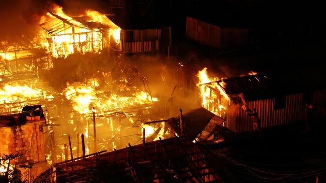 Warga berusaha memadamkan api dengan air saat kebakaran di lingkungan Educandos, di Manaus, Brasil (17/12). Para pihak berwenang mengatakan setidaknya 600 rumah kayu hangus terbakar. (AP Photo/Edmar Barros)
