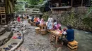 Pelanggan makan siang di restoran dengan meja di aliran sungai di Kampung Kemensah di pinggiran Kuala Lumpur pada 14 Juli 2020.(Mohd RASFAN / AFP)