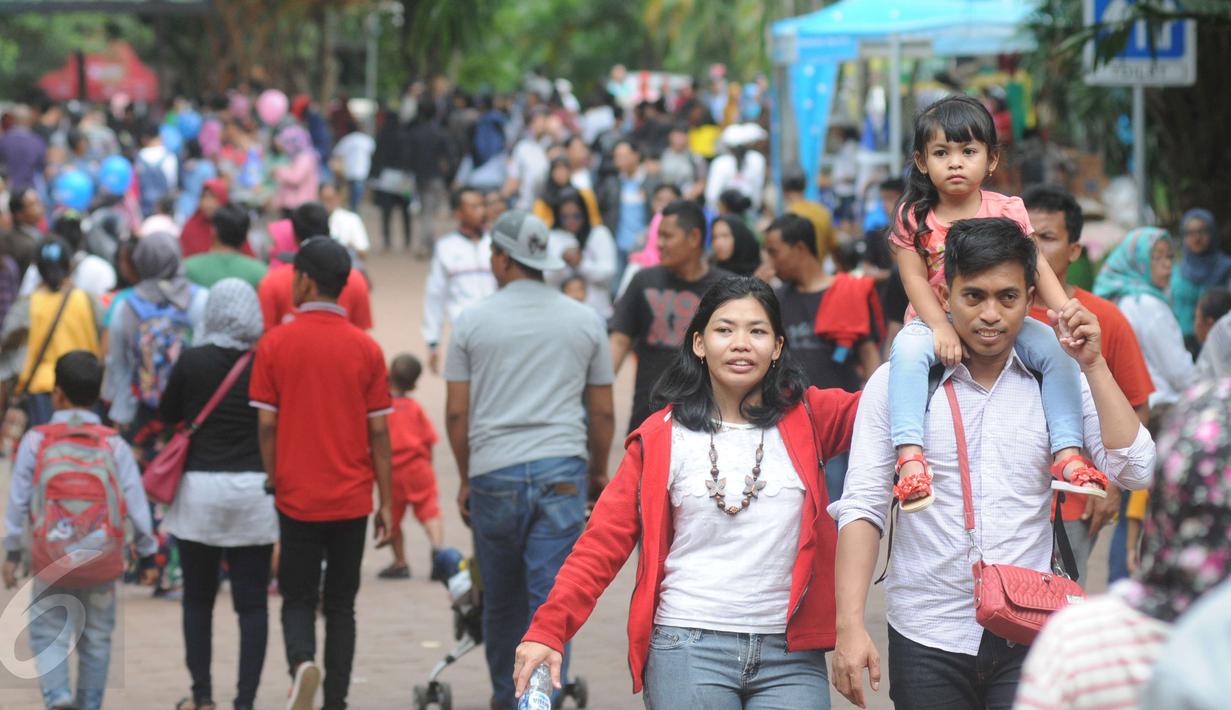 Seorang pengunjung menggendong anaknya saat berkunjung ke Ragunan, Jakarta, Minggu (25/12). Libur Natal dimanfaatkan warga untuk rekreasi bersama keluarga ke Ragunan. (Liputan6.com/Helmi Afandi)