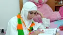 Baby Margaretha membaca buku seputar menjelang keberangkatannya ke tanah suci, Jakarta, Kamis (5/6/2014) (Liputan6.com/Panji Diksana)