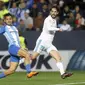 Pemain Real Madrid, Isco (kanan) melepaskan tembakan melewati adangan pemain Malaga, Roberto Jose Rosales pada lanjutan La Liga Santander di Rosaleda stadium, Malaga, (15/4/2018). Madrid menang 2-1. (AP/Miguel Morenatti)