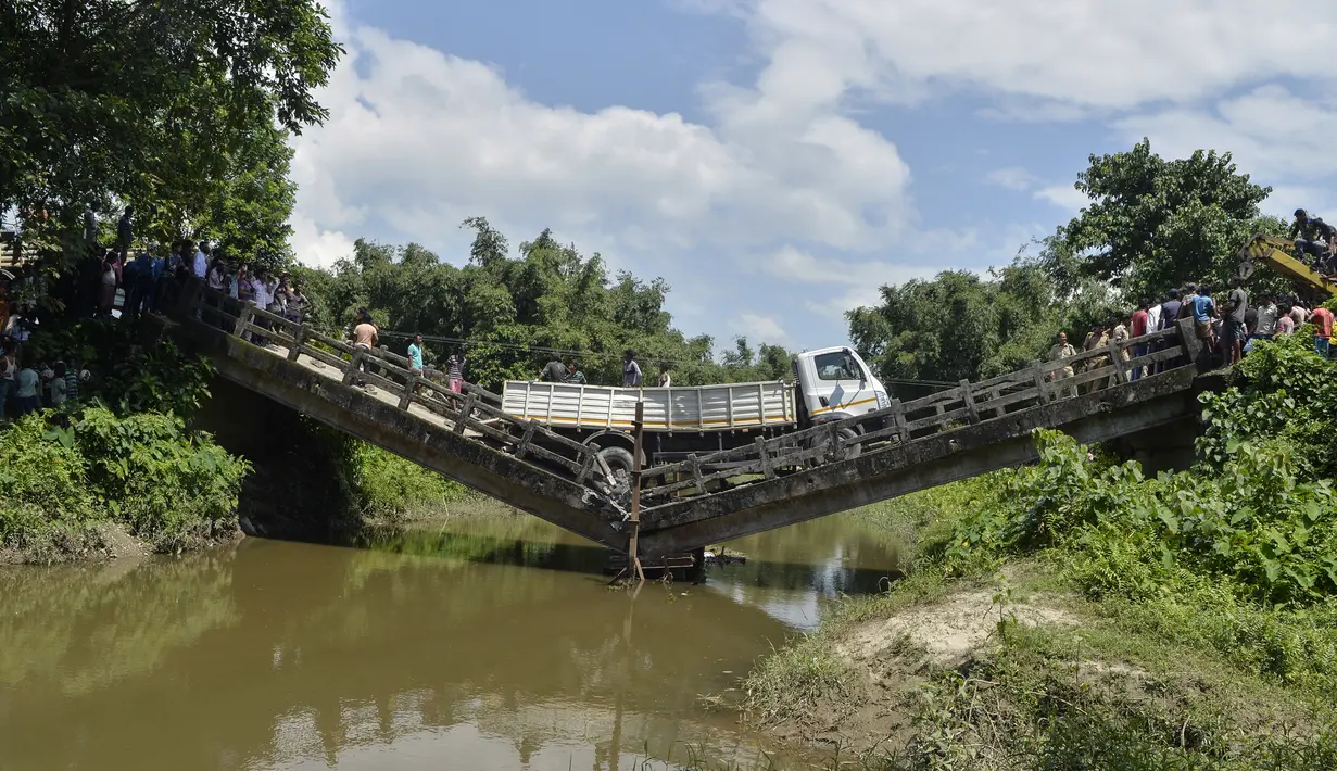 Sebuah truk berada di jembatan yang roboh di desa Phasidewa dekat perbatasan India-Bangladesh di pinggiran Siliguri di negara bagian India, Bengal Barat (7/9). Tidak ada korban dalam kejadian jembatan roboh tersebut. (AFP Photo/Diptendu Dutta)