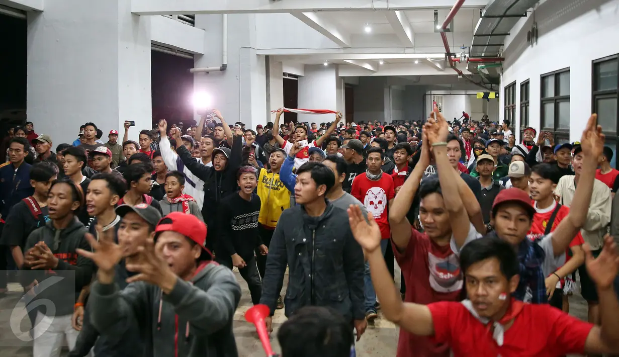 Pendukung Timnas Indonesia memaksa masuk ke dalam tribun saat berlangsungnya leg pertama final Piala AFF 2016 di Stadion Pakansari, Bogor, Rabu (14/12). Kapasitas tribun yang sudah penuh membuat petugas jaga menutup pintu masuk. (Liputan6.com/Johan Tallo)
