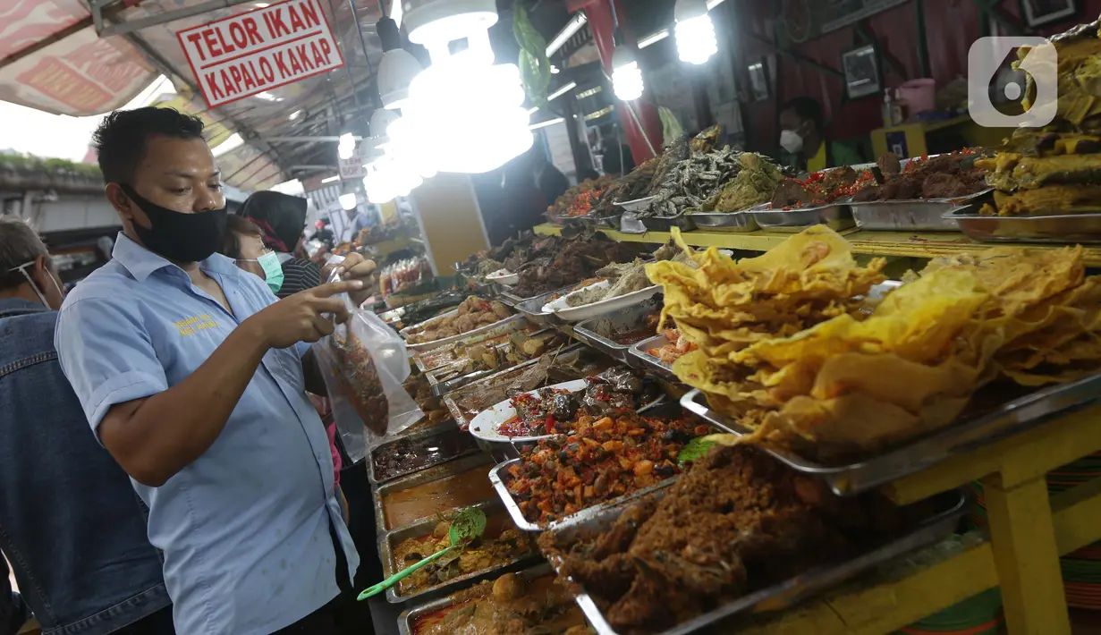 Pedagang melayani pembelian makanan khas Sumatera Barat di kawasan Food Street Kramat, Jakarta, Jumat (30/4/2021). Kawasan yang menjual beragam menu makanan khas Sumatera Barat selalu ramai dikunjungi pecinta kuliner terutama jelang waktu berbuka puasa. (Liputan6.com/Helmi Fithriansyah)