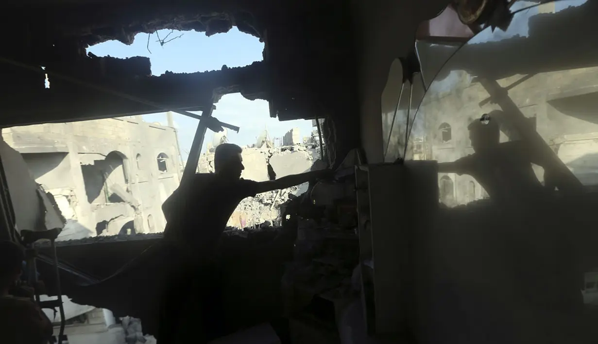 Israel meluncurkan lebih dari 20 serangan udara ke kota Gaza pada Sabtu, (9/8/2014). Salah satu warga memeriksa kondisi rumahnya yang rusak parah akibat serangan militer udara Israel. (REUTERS/Mohammed Salem)