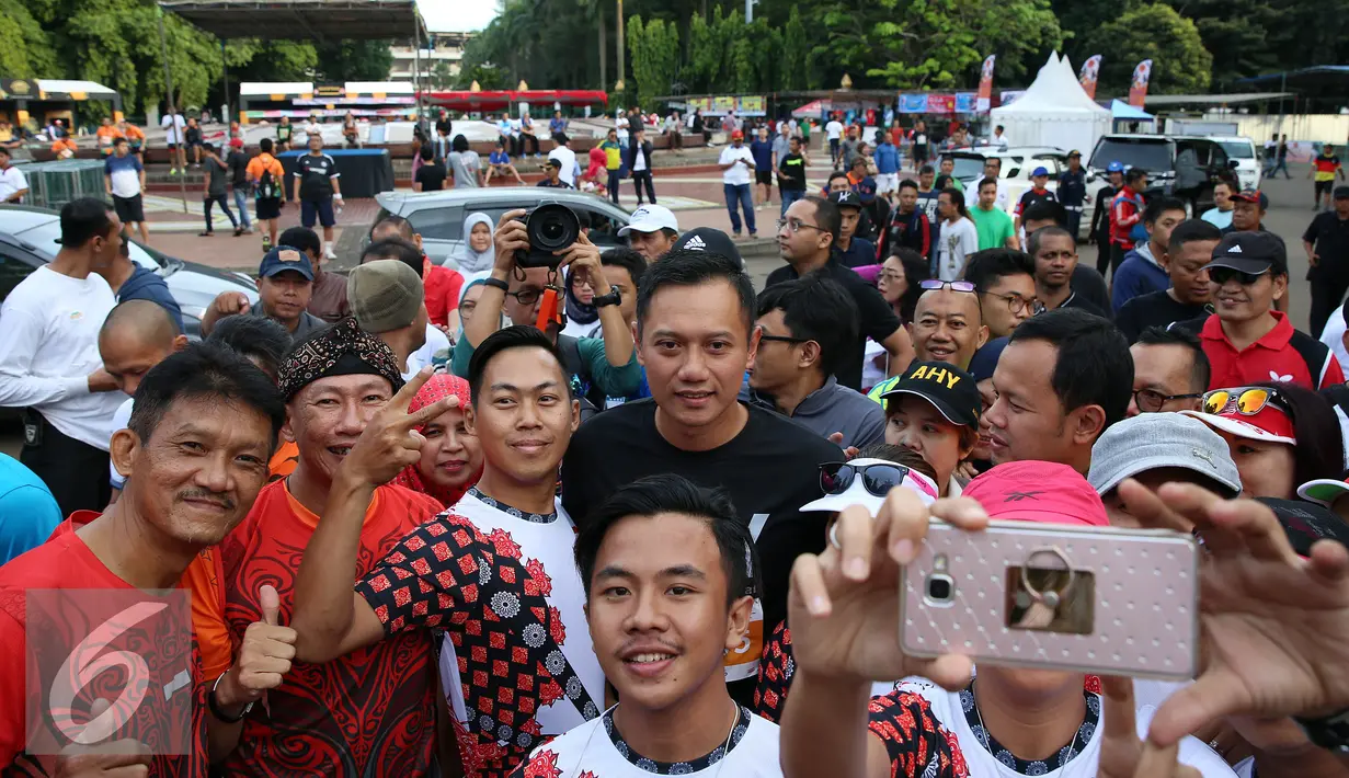 Calon Gubernur DKI Jakarta Agus Harimurti Yudhoyono berfoto selvie dengan warga Jakarta saat mengikuti kompetisi lari di CFD kawasan Senayan, Minggu (2/10). (Liputan6.com/Johan Tallo)
