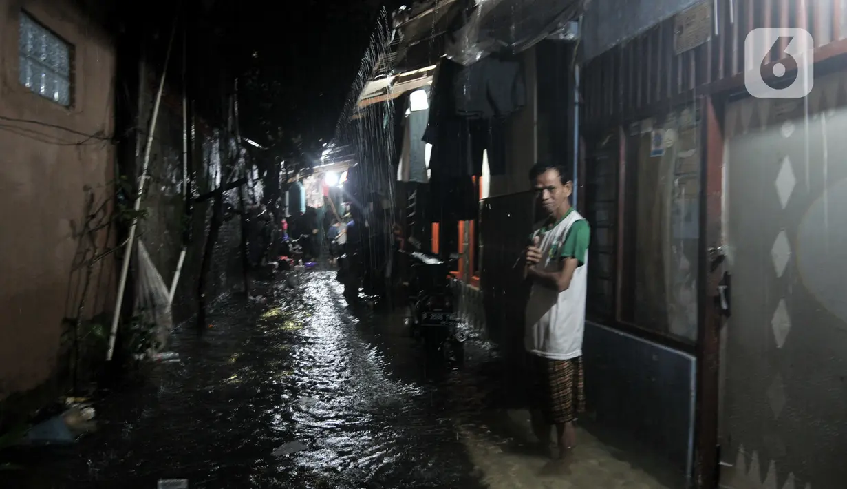 Warga berada di depan rumah saat banjir di kawasan Cipinang, Jakarta Timur, Minggu (23/2/2020) dini hari. Hujan deras yang mengguyur Jakarta dan sekitarnya sejak Sabtu malam ditambah buruknya drainase menyebabkan ratusan rumah di Cipinang terendam banjir. (merdeka.com/Iqbal S. Nugroho)