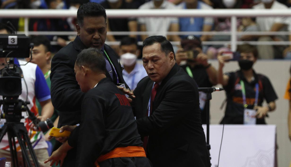 Pelatih Indonesia lainnya, Indro Catur Haryono (tengah) pun berusaha melerai dan menenangkan Benny Sumarsono yang juga menjabat sebagai Ketua Eksekutif Persekutuan Pencak Silat Antarabangsa (Persilat). (Bola.com/Ikhwan Yanuar)