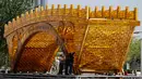 Pekerja memasang kabel pada struktur 'Golden Bridge Silk Road' di Beijing, China (18/4). Forum tersebut bertujuan untuk membangun jaringan perdagangan dan infrastruktur yang menghubungkan Asia dengan Eropa dan Afrika. (AP Photo/Andy Wong)