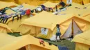 Seorang gadis di dekat tenda di  sebuah kamp yang dibangun untuk para migran Venezuela yang tunawisma di Bogota, Kolombia (21/11). Kamp ini dapat menampung lebih dari 400 orang. (AP Photo/Ivan Valencia)
